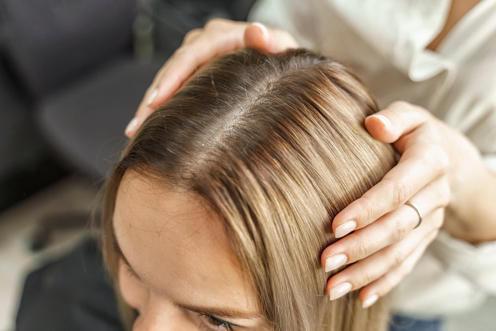 Kobieta o półdługich włosach blond farbowanych i cieniowanym cięciu