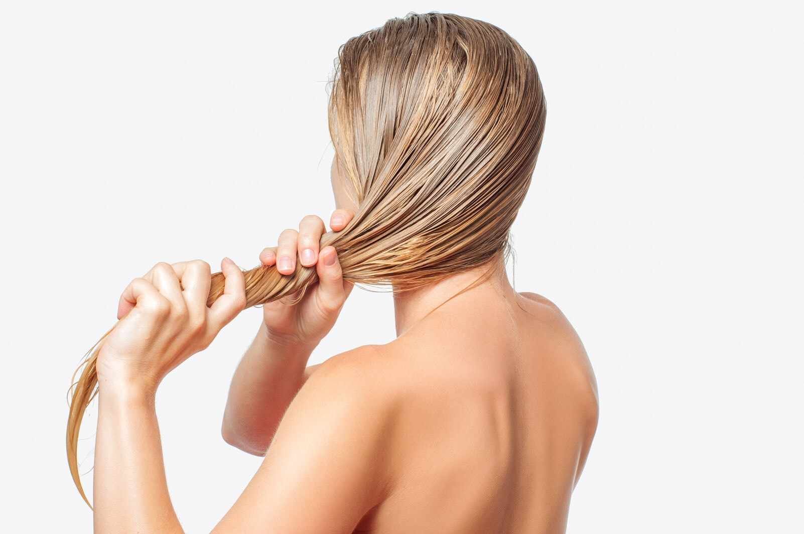 Kobieta plecie mokre blond włosy na białym tle.