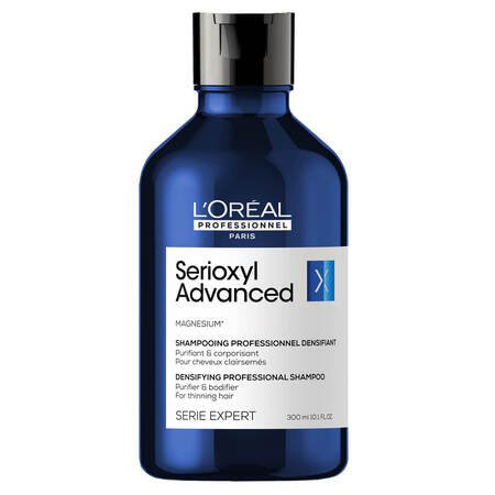Niebieska butelka szamponu L’Oréal Serioxyl Advanced stoi na białym tle.