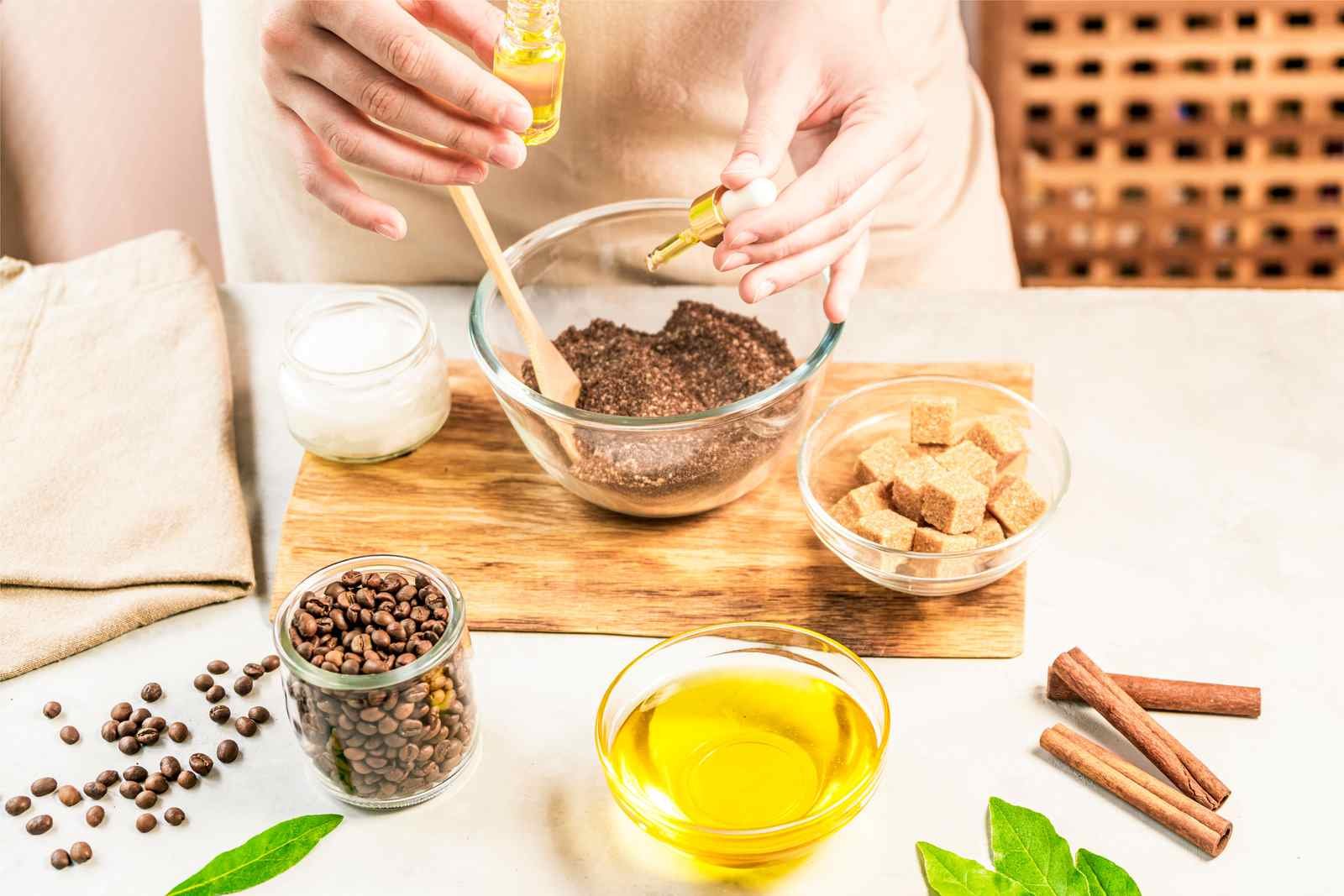Kobieta miesza składniki w miseczce, przygotowując domowy peeling kawowy z dodatkiem oleju.